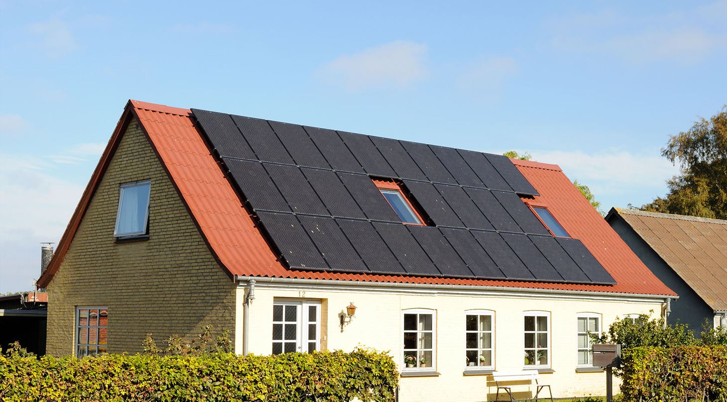 Sådan kan du forbedre energimærket på dit hus. Billede af hus med solceller på taget.